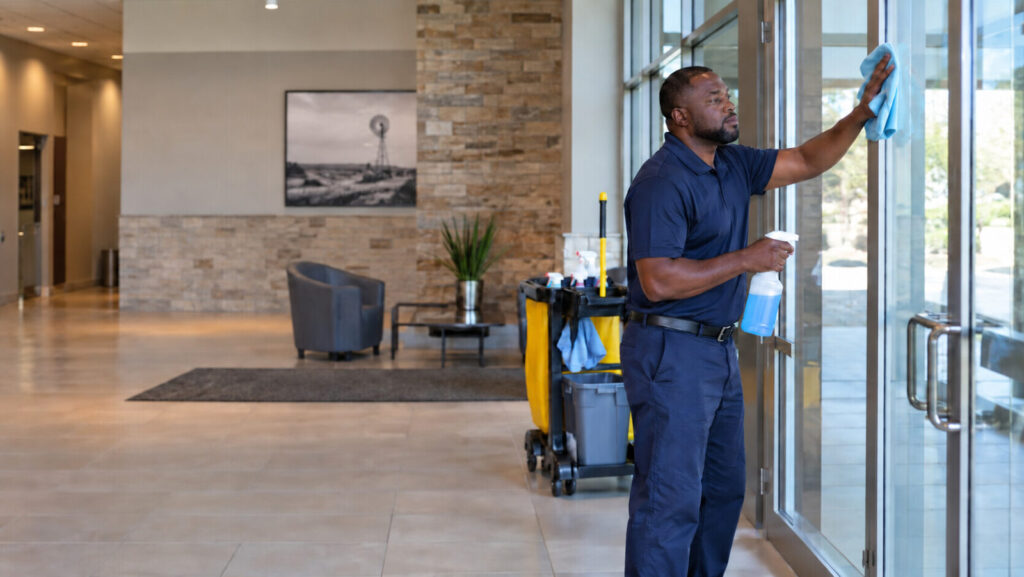 TrueGleam Cleaning technician cleaning glass entry doors
